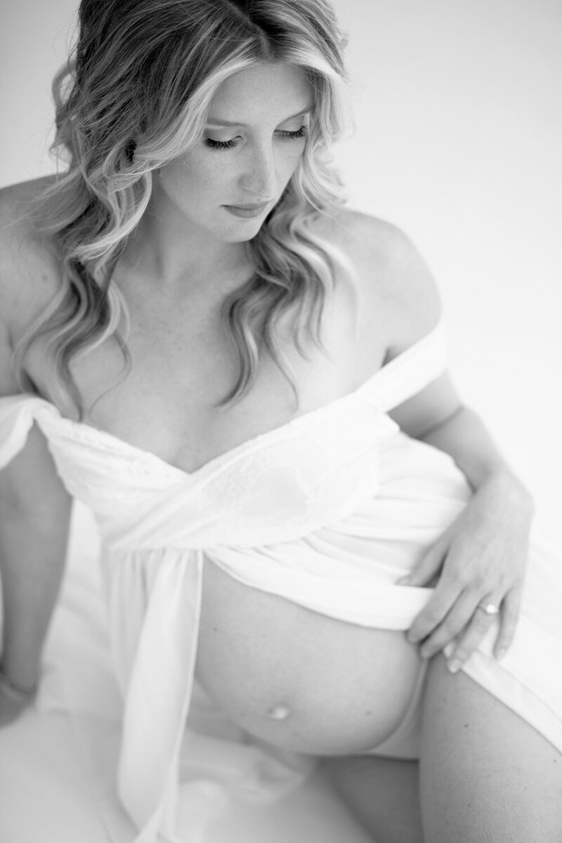 Blonde pregnant woman embraces her belly