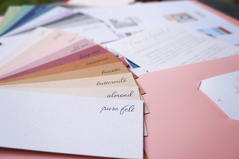 Warm colours of paper swatches in a wedding invitations sample pack