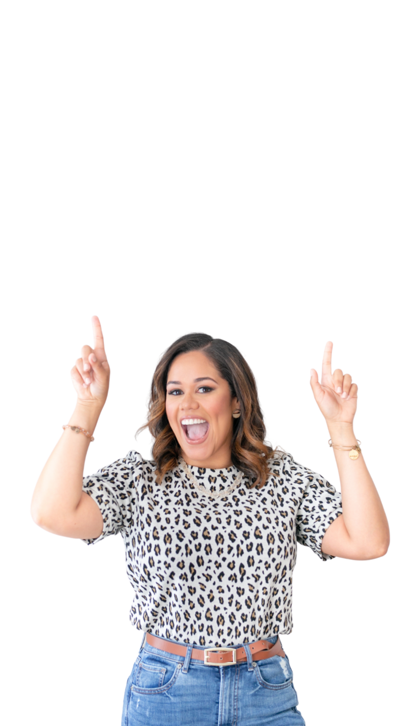 Orlando Realtor photo with hands in the air with a cheetah pattern blouse and blue jeans