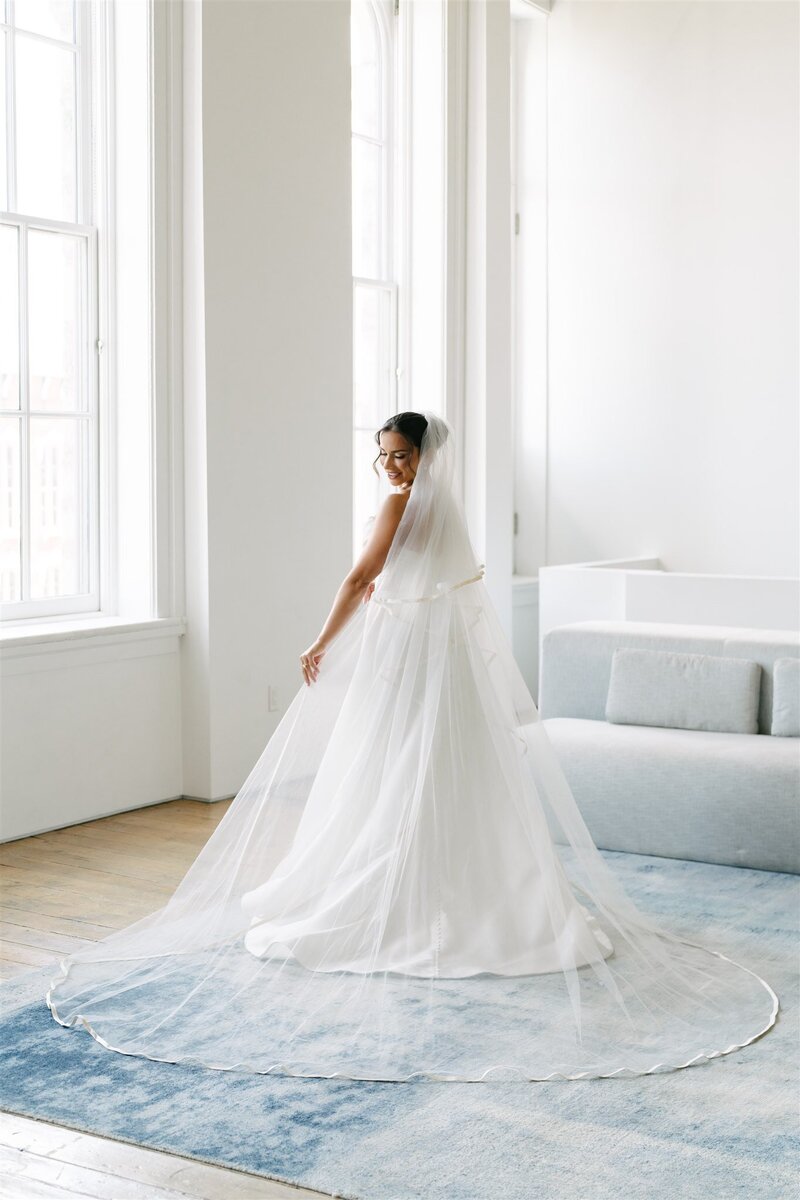 bride standing in tall room in her wedding dress