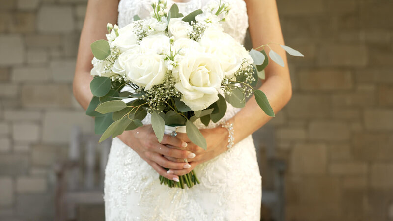 Bride holding bouquet of white florals at Long Island wedding