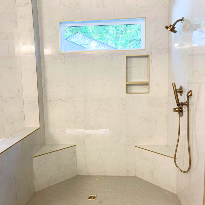 Custom shower with white tile and brushed gold  hardware.