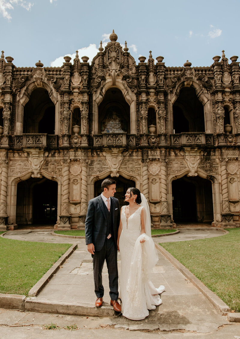 A moody wedding photo in front of a castle