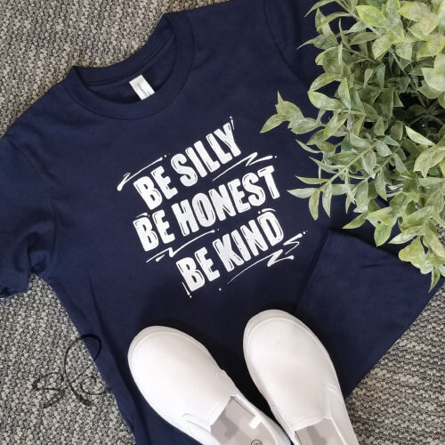 Blue t-shirt with hand lettered text "be silly, be honest, be kind"