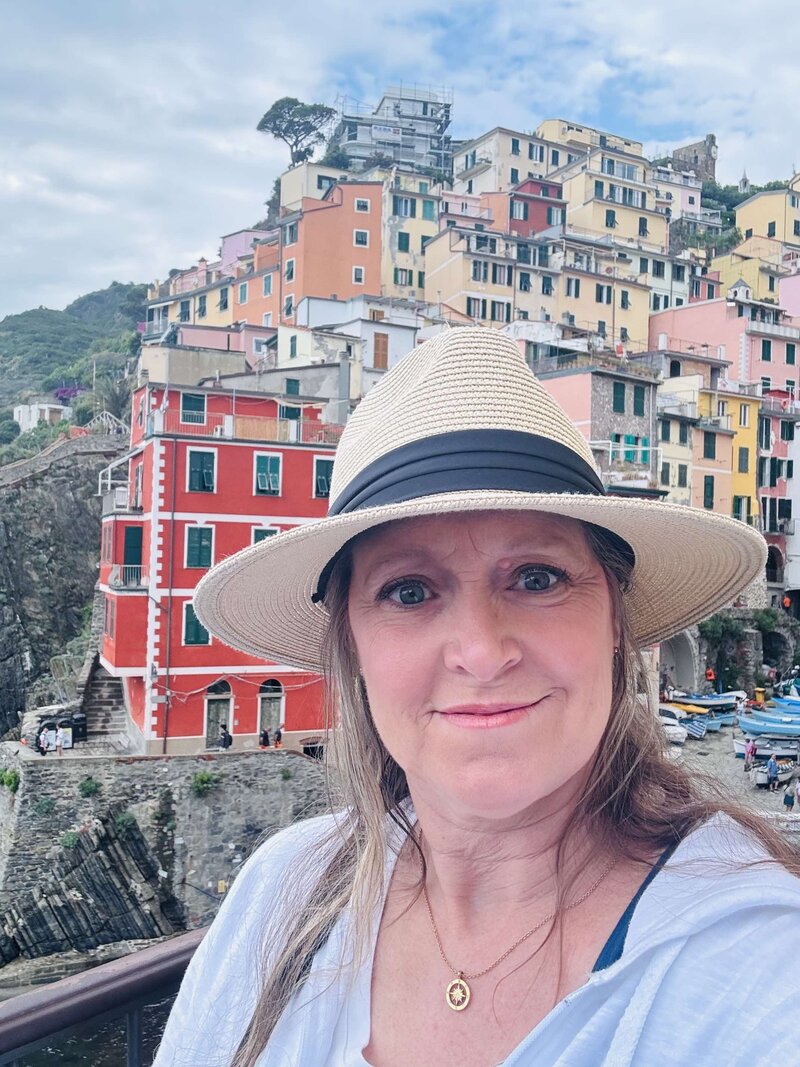 Terra, founder of Adventures by Terra, in Cinque Terre, Italy, with the buildings behind her up on a cliff