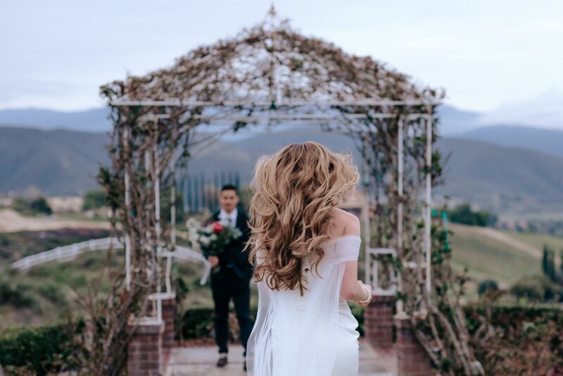 Bride running down the isle to her Groom who is waiting for her with her flowers.