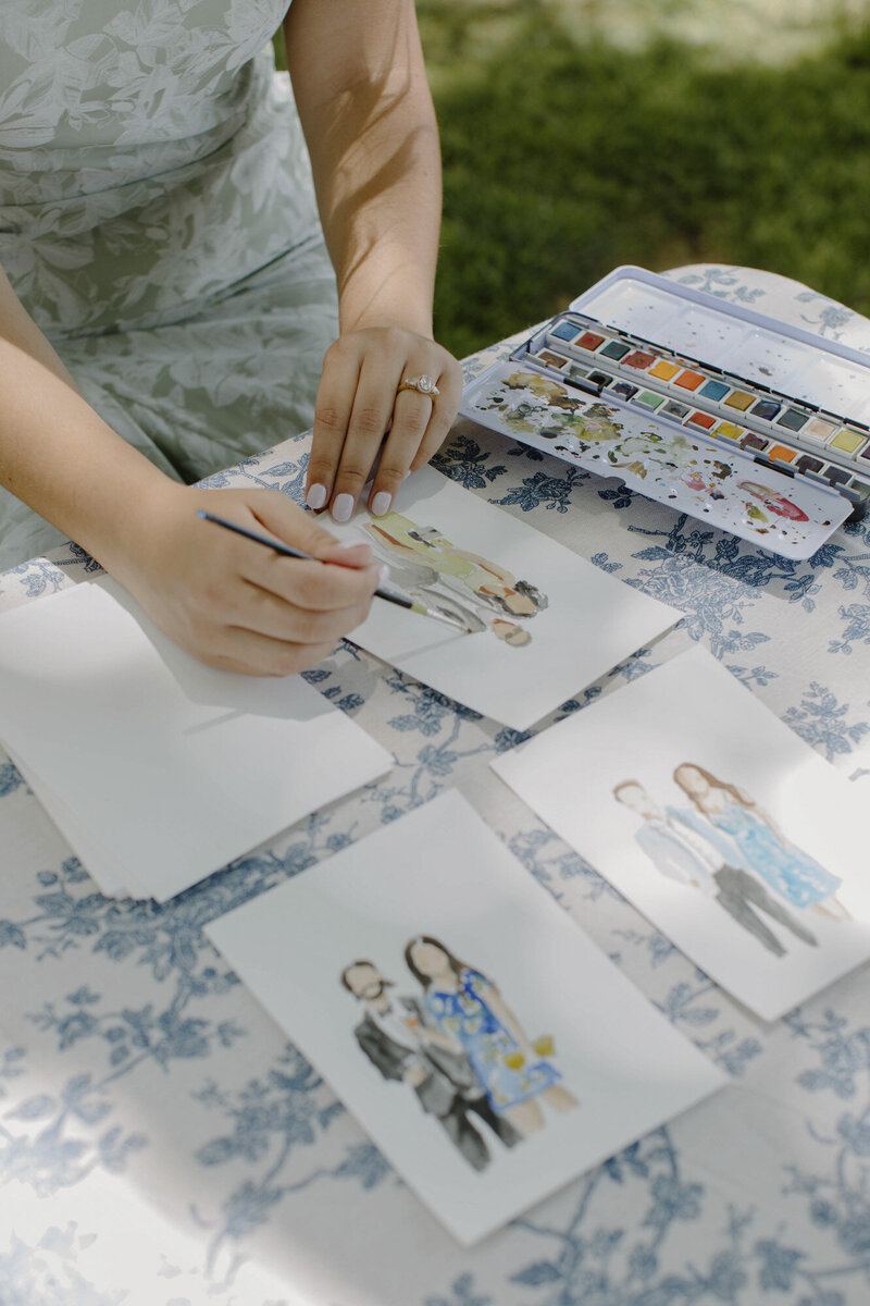 Watercolor guest portraits laid out on a table