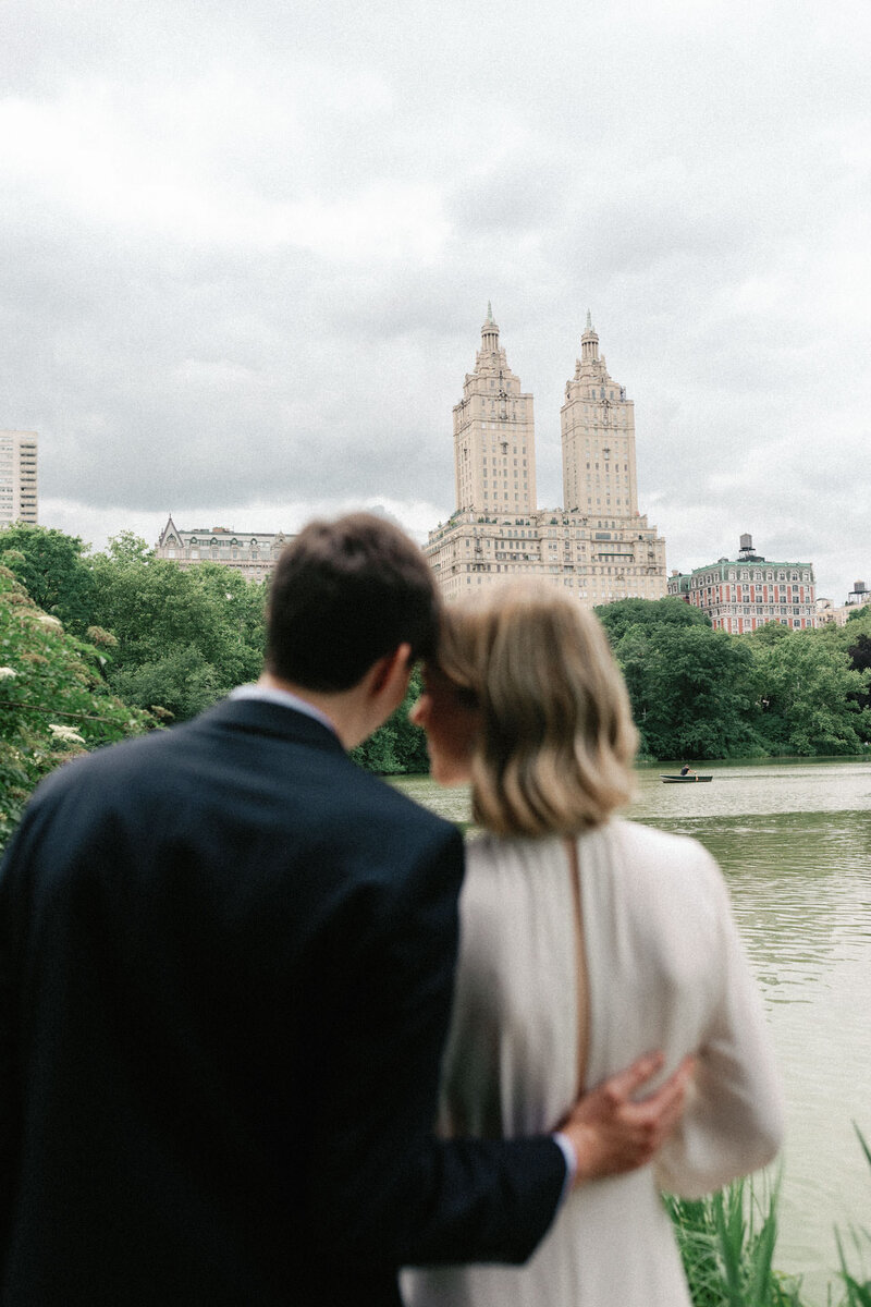 NYC elopement couple in central park kissing with flowers and san remo