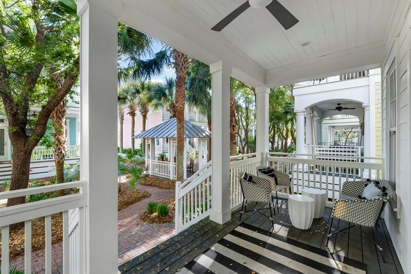 Peaceful shaded porch with seating and view of nearby gazebo in charming 30A neighborhood