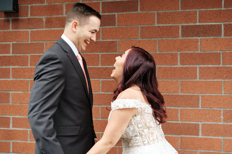 Bride and groom laugh during the first look