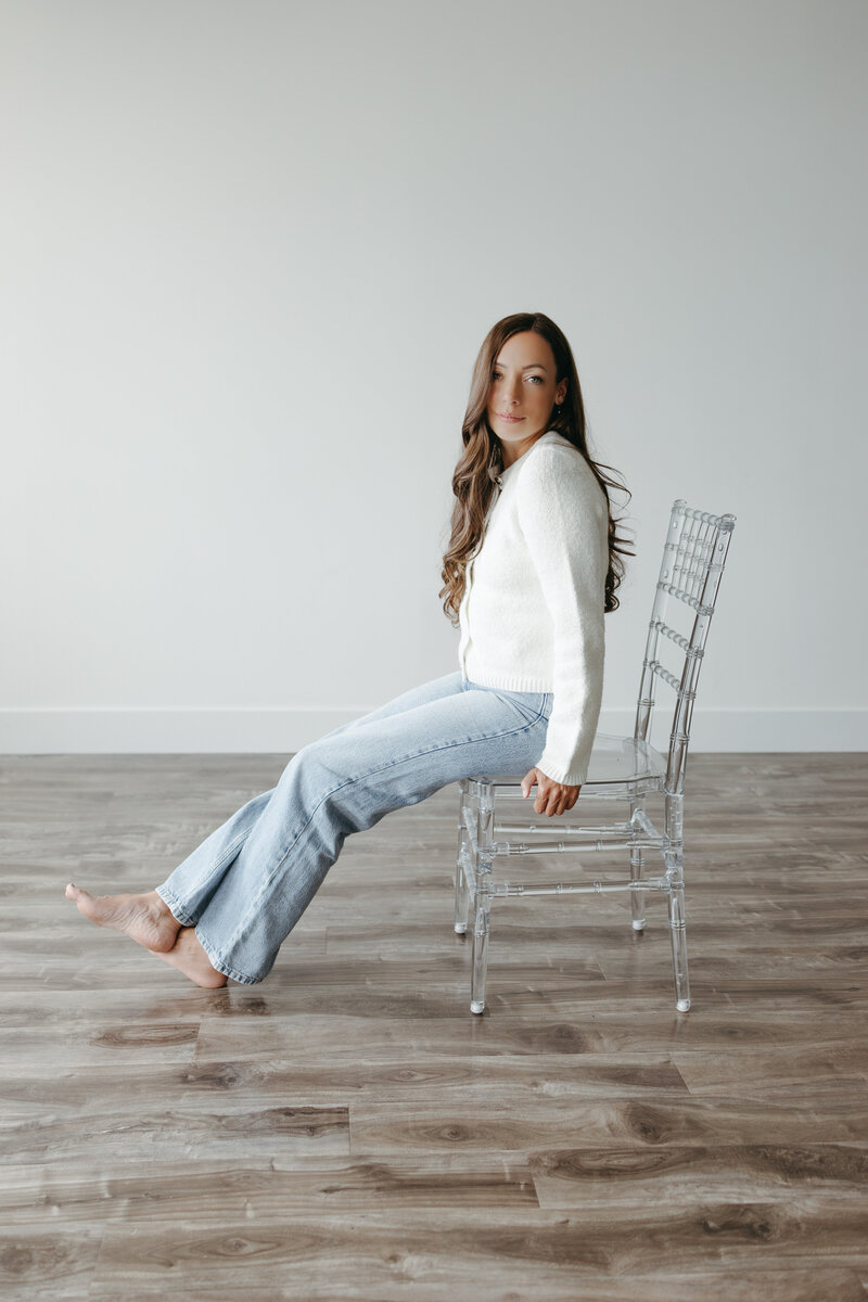 The owner of Katharina Luise photo is sitting on a chair and is looking at the camera. 