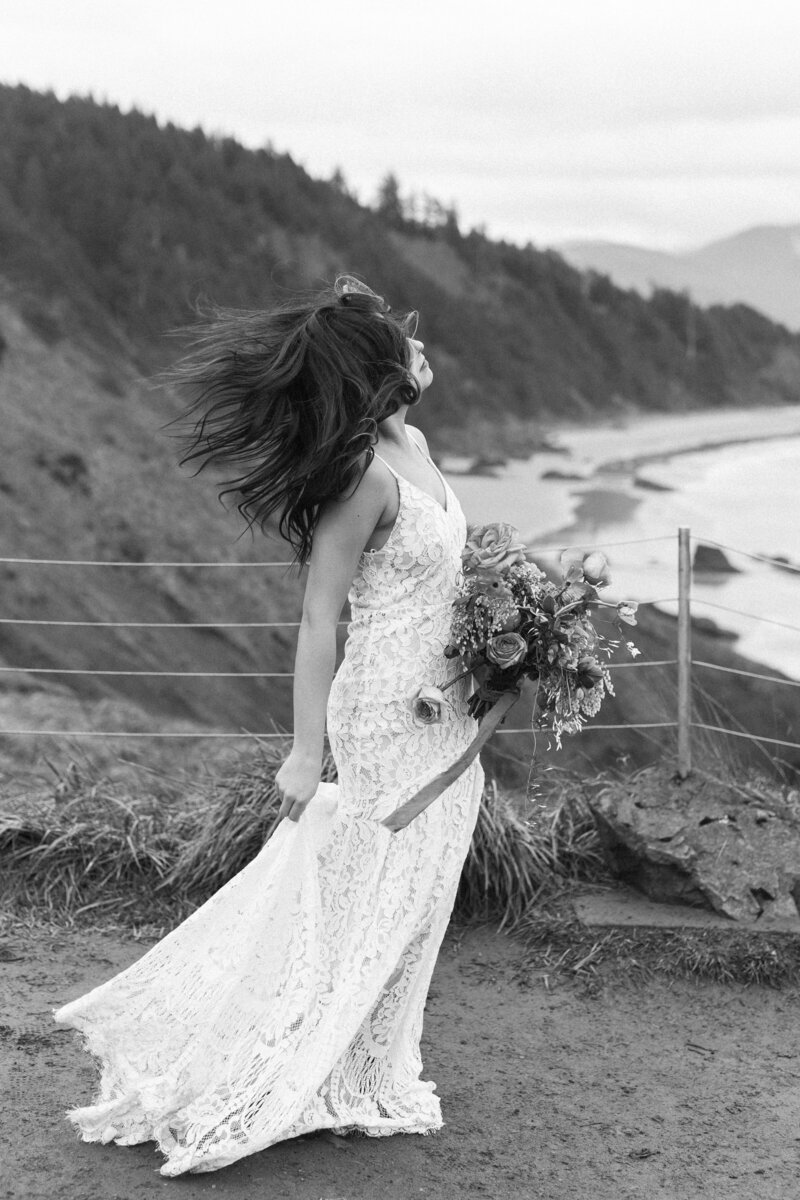 a bride's hair blown by the wind; the bride is holding a bouquet and her dress