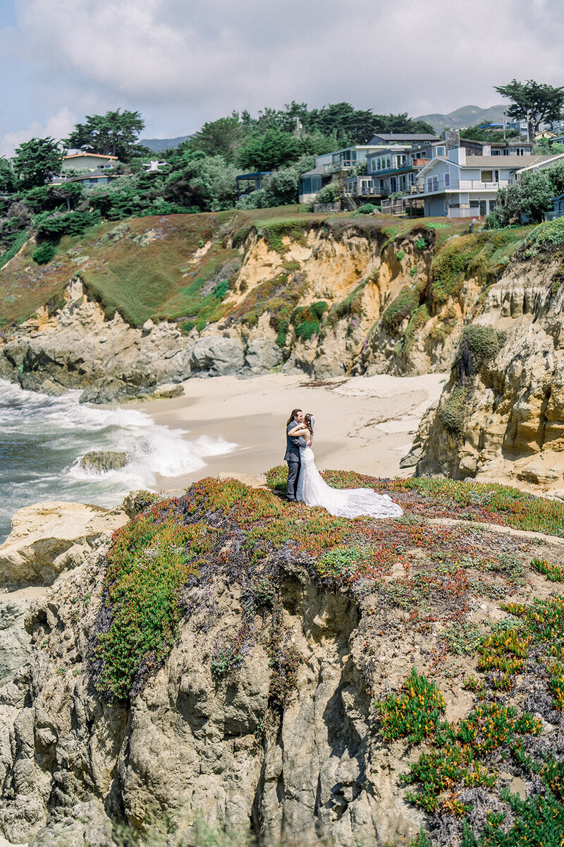 A stunning California wedding set against the backdrop of scenic coastal cliffs. The couple embraced the beauty of nature with an intimate ceremony on the edge of the ocean, the waves crashing below. The bride’s flowing gown trails gracefully along the cliffside, adding to the romantic ambiance. The lush greenery and ocean views create a breathtaking contrast, making this wedding a dream for any couple seeking a picturesque California beach celebration. Perfect for lovers of seaside elegance and natural beauty.