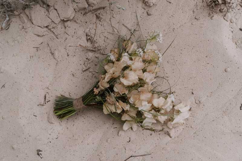floral bouquet laying in the sand