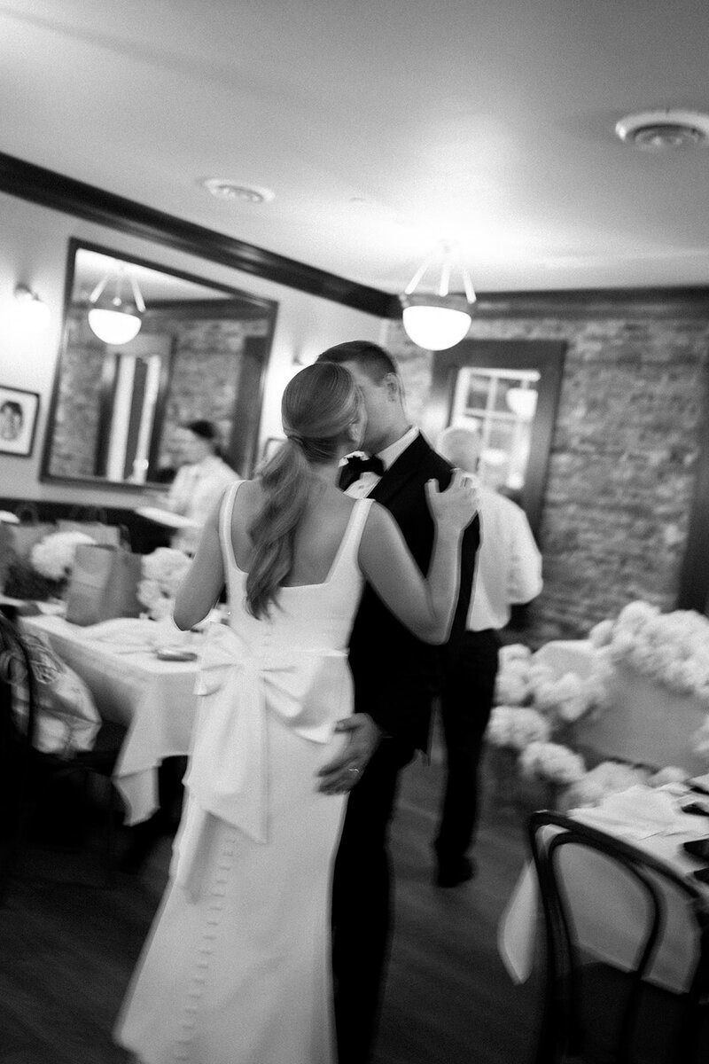 Black and white photo of bride and groom kissing in the middle of their reception in Cape May.