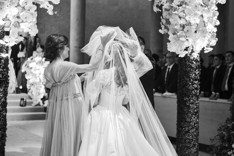 Groom spinning bride in between white columns