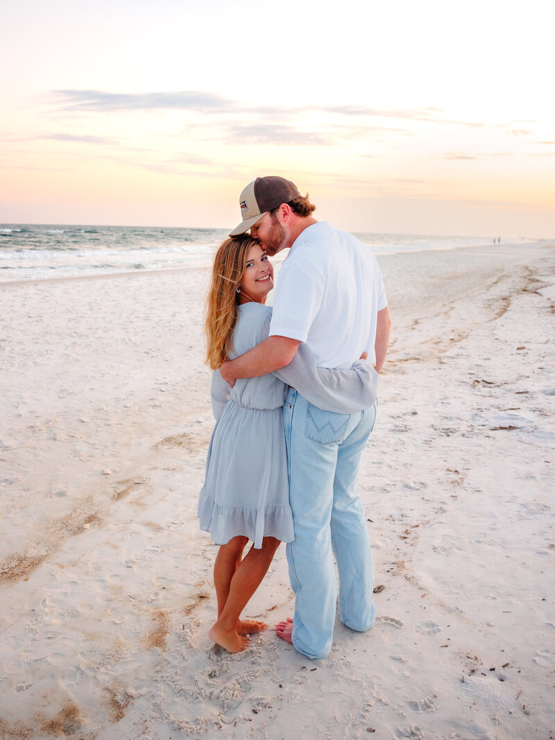 Over the should with girl looking at camera with kiss from boyfriend