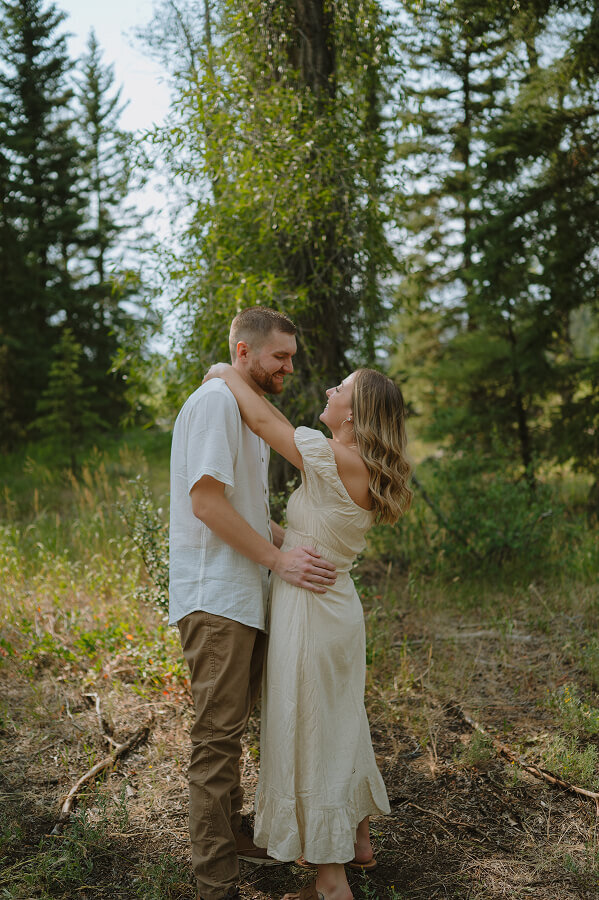 A couple is slow dancing in a forest together during a lifestyle couples session in Swan Valley, ID.