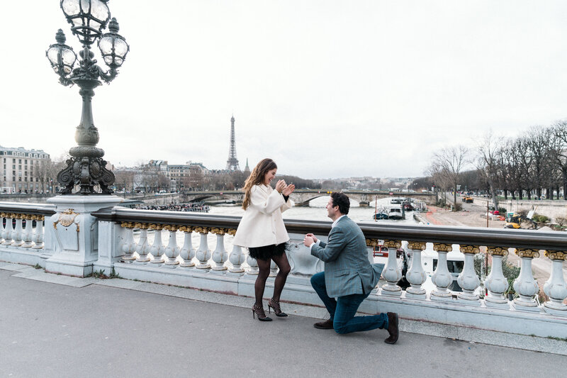 man presenting a ring at the eiffel tower