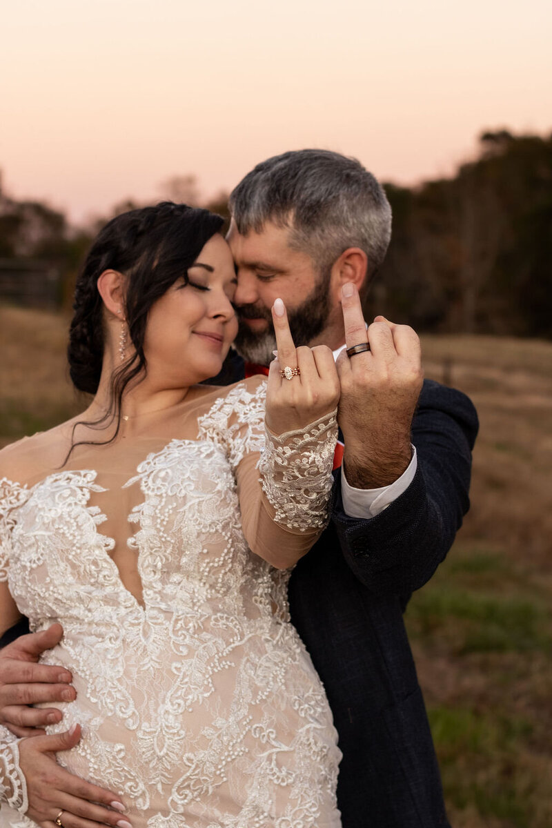 Playful wedding couple showing their ring fingers to the camera during their Utah wedding, photographed by Lamblight Photography