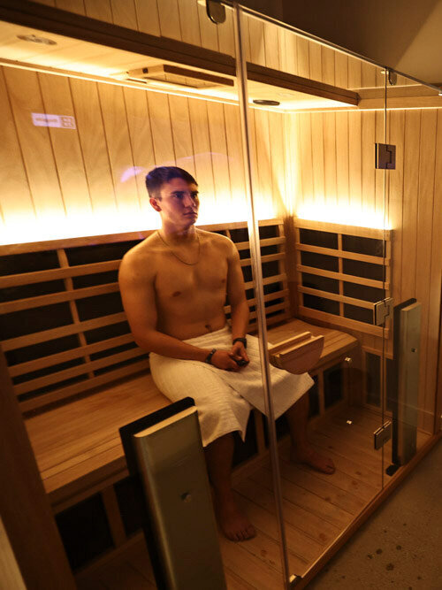 man and woman back to back on an infrared sauna bench