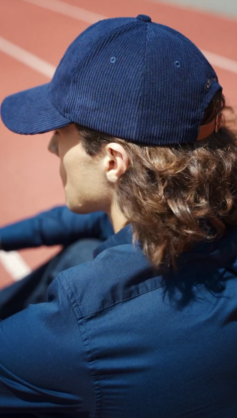 Photo fashion de Iker Jiménez, look sport chic Ralph Lauren, mise en scène sur piste d'athlétisme