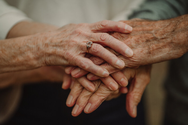 Grandparents and daughters hands bundled together.