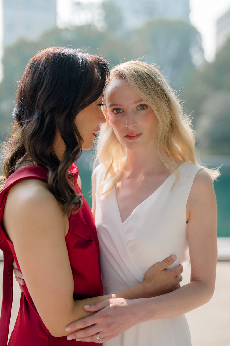 A lesbian couple embraces and poses for a portrait on their wedding day.