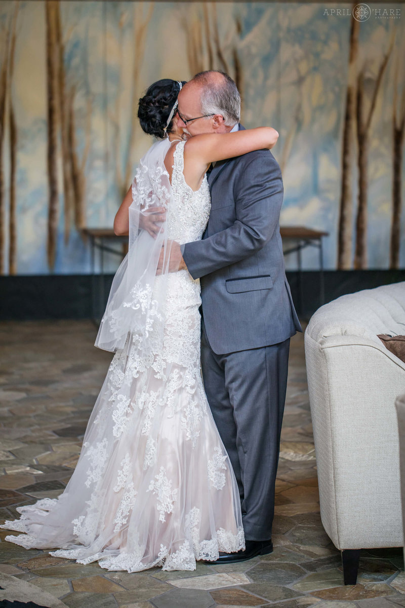 Father hugs his daughter on her wedding day in the lobby at Bluesky Breckenridge
