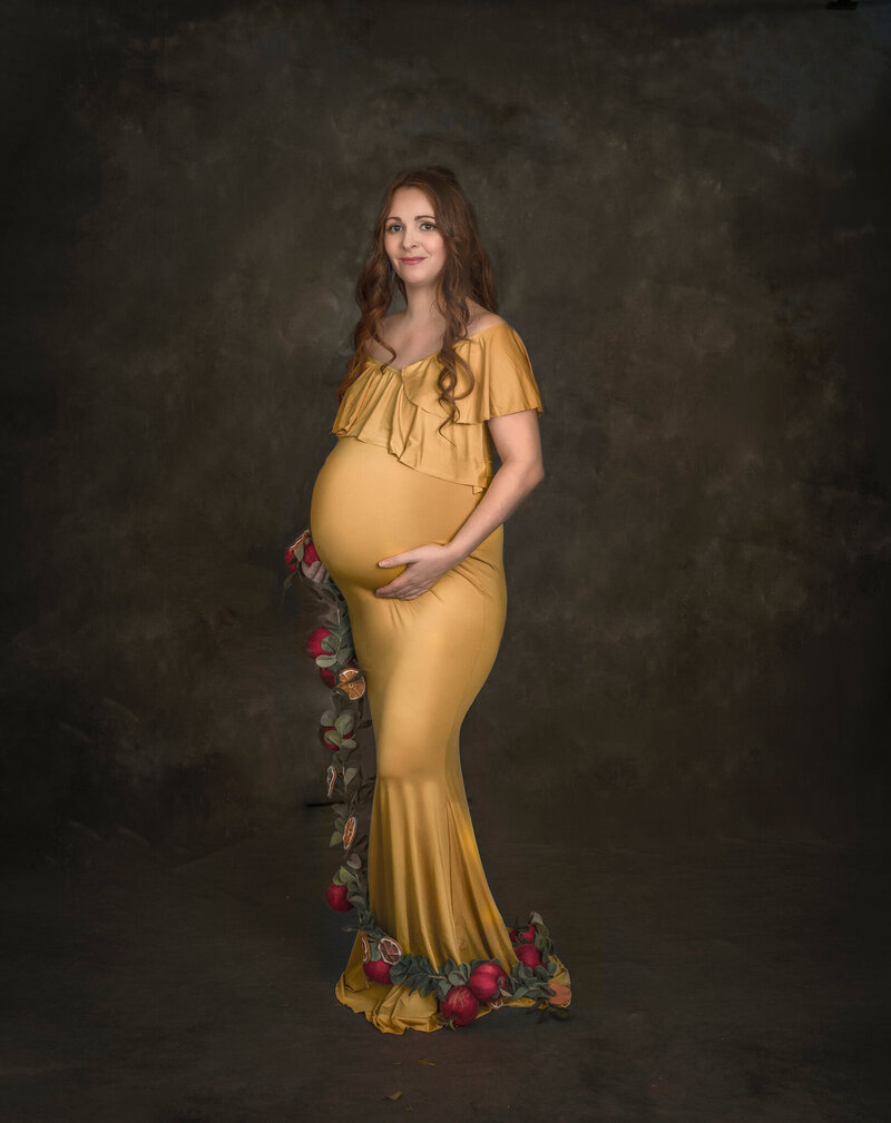  "Pregnant mom in a vibrant yellow maternity gown, captured in a beautiful and elegant studio maternity photography session in Ottawa."