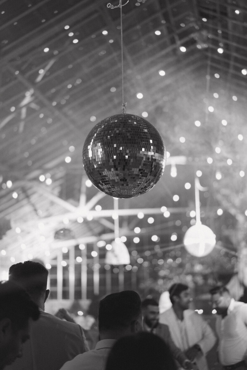 Disco ball sparkles and gives a fun ambiance during the wedding reception at Dos Pueblos Orchid Farm in Santa Barbara, CA.