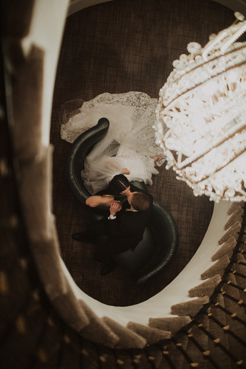 Couple kisses under chandelier at Hotel Washington wedding venue