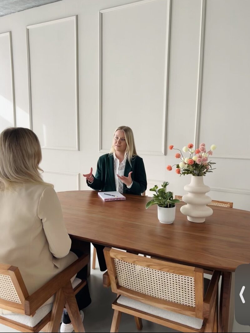Sex Counselor sitting on green sofa smiling towards camera