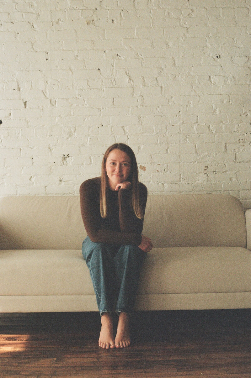 girl on beige couch for portraits in Wisconsin studio