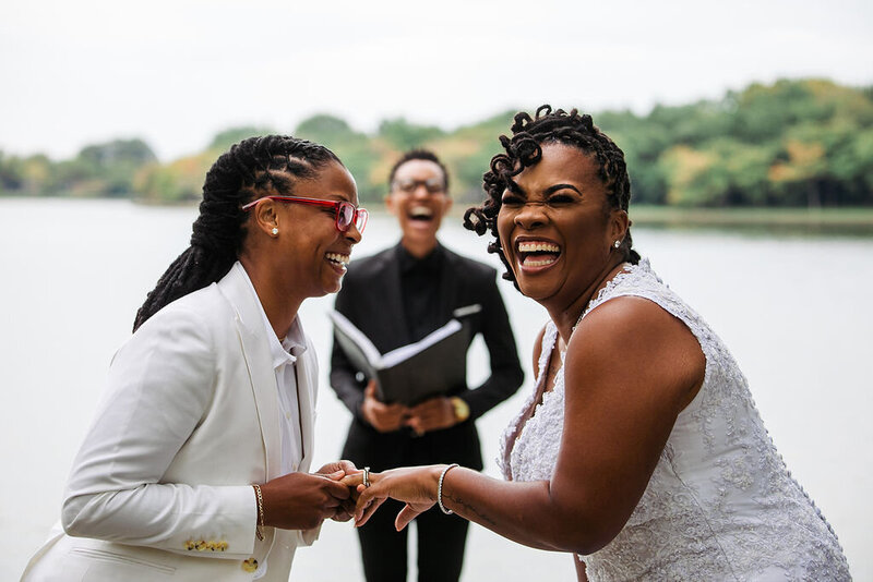 A couple holding hands and laughing during their wedding ceremony