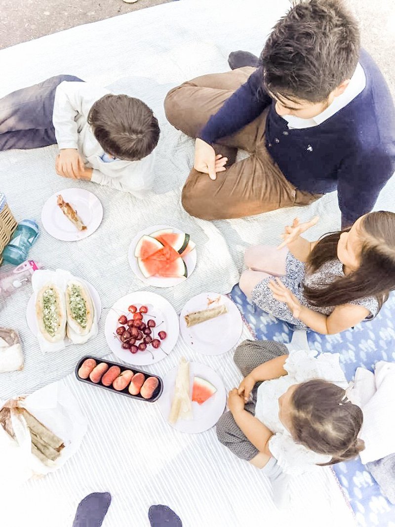 En familie som vi ser ned på som spiser piknik utendørs