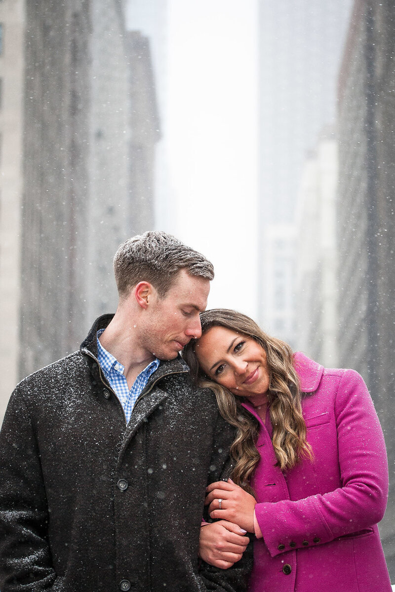 couple walk woodward during snowy winter detroit engagement session
