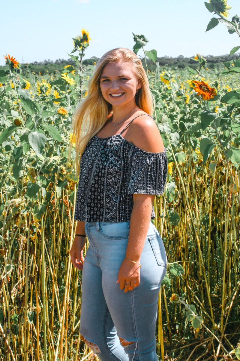 Madi standing in front of a sunflower field