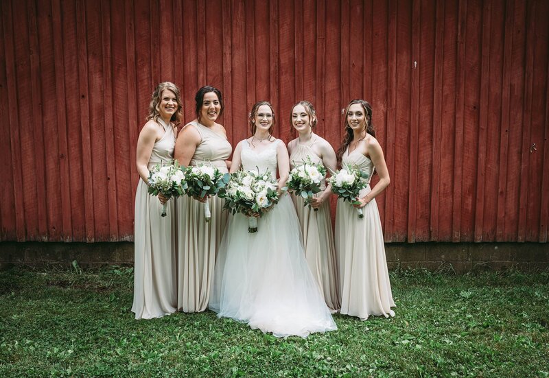 bride smiling with her bridesmaids surrounding her