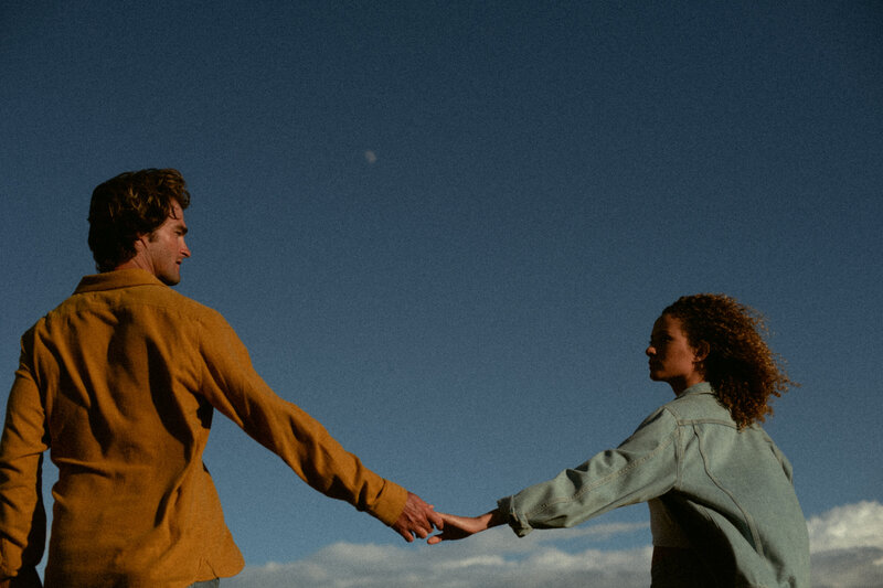 Couple holding hands with the moon