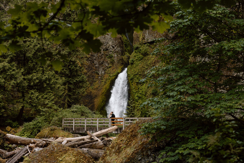 Couple on a bridge in front of a waterfall at the Columbia River Gorge
