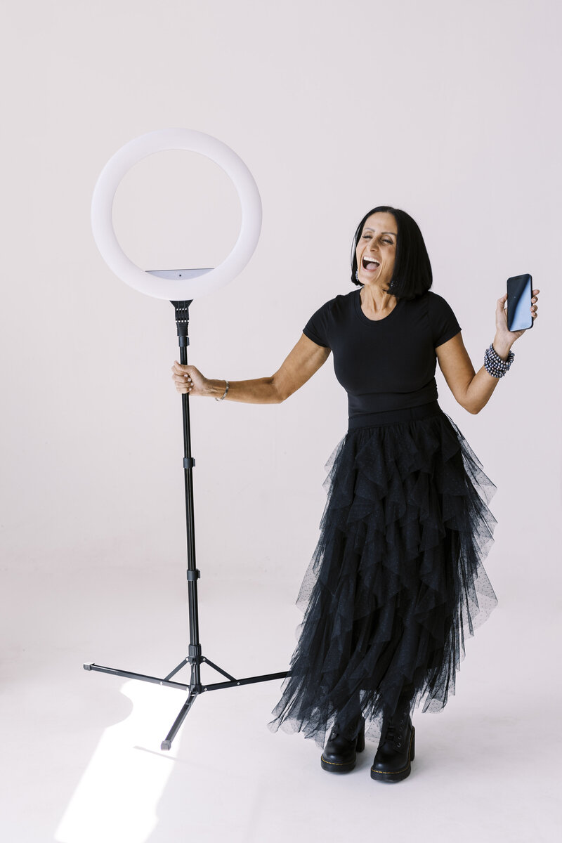 Tarah wearing a black tool dress holding stage light