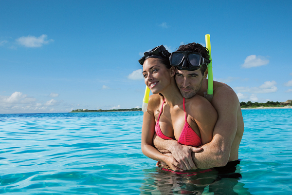 Couple snorkeling in clear blue water at Secrets St. Lucia Resort & Spa.