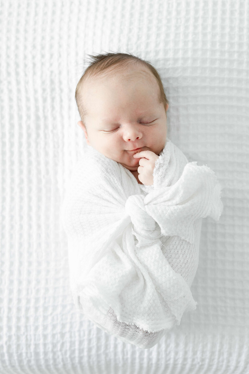 Newborn baby wrapped and sleeping during newborn photography session in Dothan Alabama Photography Studio