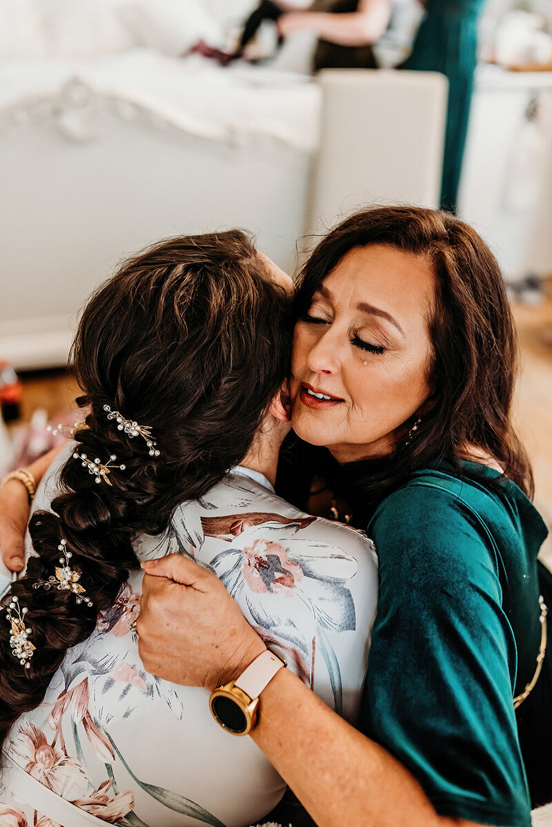 a mom and daughter embracing, crying