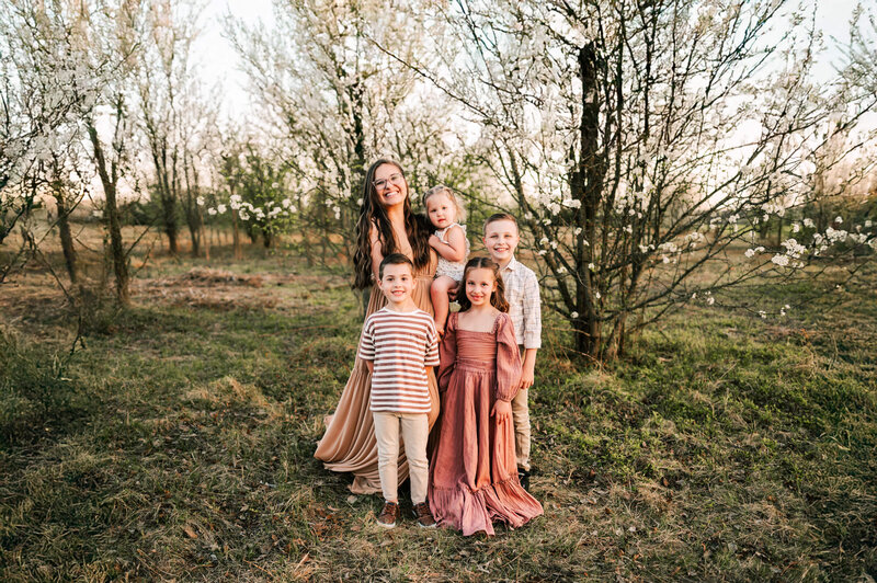 family photo cuddling in flower blossoms