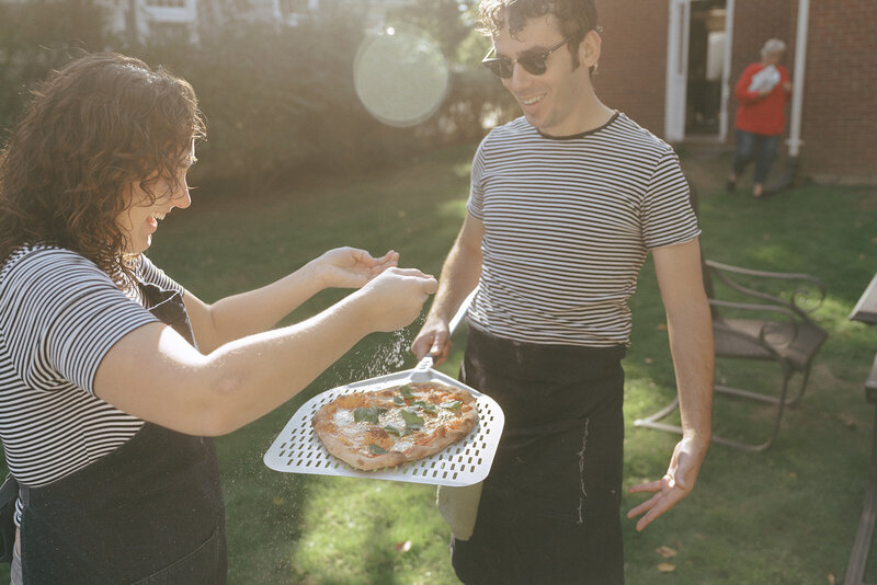 couple making pizza during at home engagement photos, captured by Elsie Goodman, an NYC engagement and couples photographer