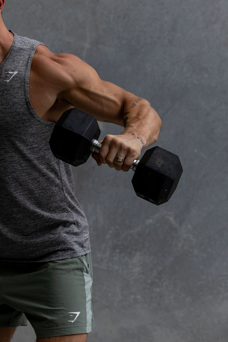 Athlete lifting weights as part of a performance routine supported by sports acupuncture