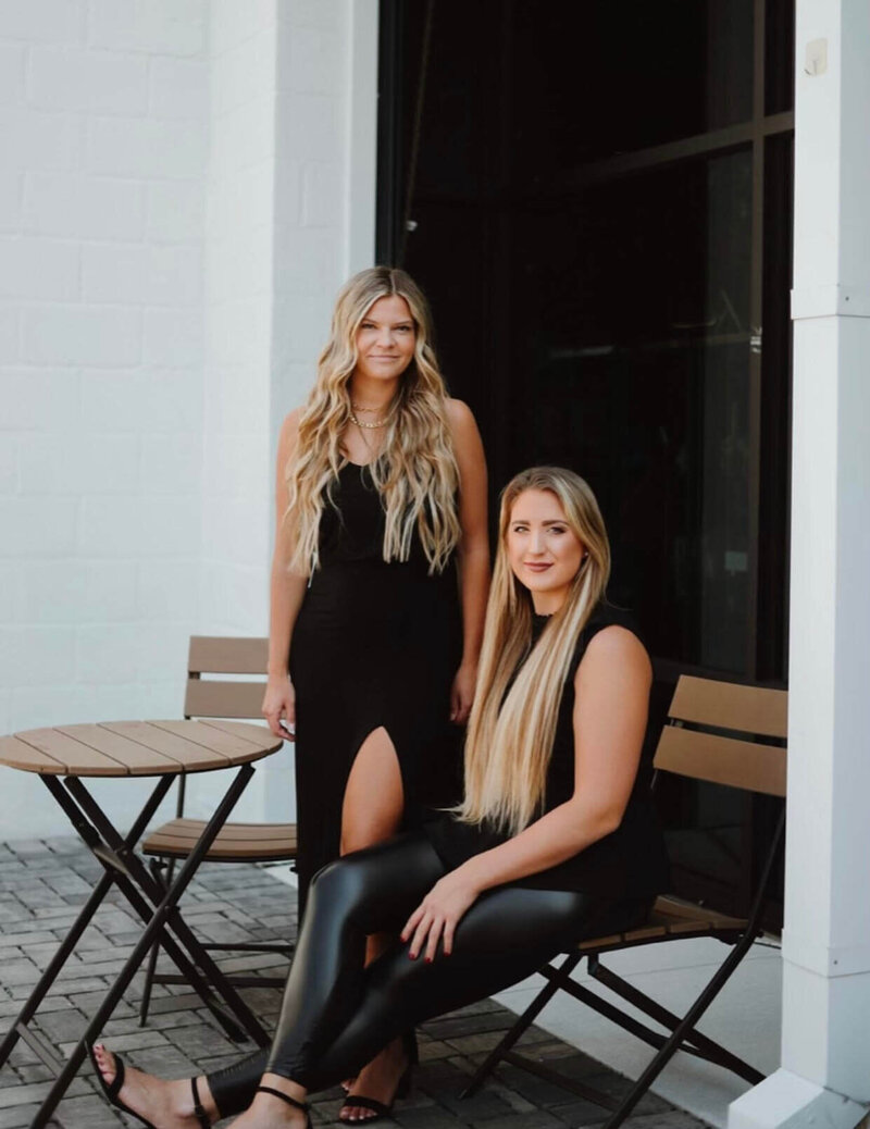 Two blonde female hair stylists posed outside building in Baltimore Maryland