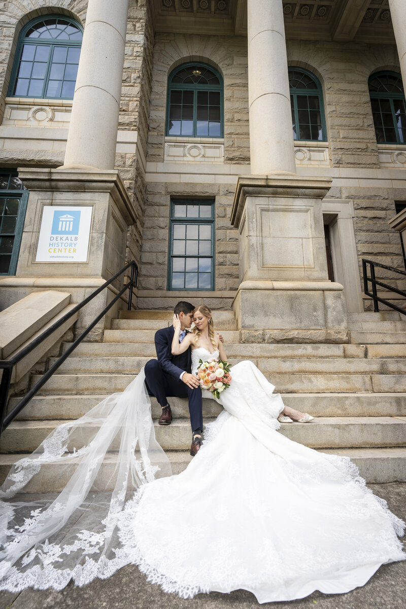 Bride and Groom sit on steps of Dekalb County Courthouse